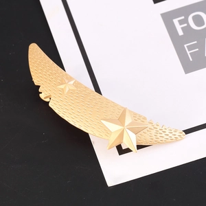 Matte gold wing-shaped hair clip with stars and textured finish for women