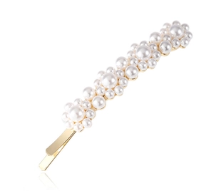 Detailed close-up of elegant gold-plated hair clip with white pearls in cluster design