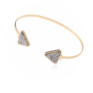 Minimalist gold cuff bracelet with white marble triangle stones in a 45-degree angle view