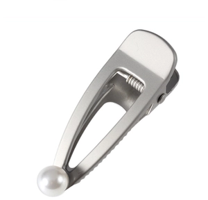 Detail of matte silver metal hair clip featuring a fine brushed texture and pearl accent