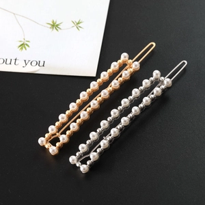 Détail de barrettes rectangulaires avec perles blanches serties en doré et argenté