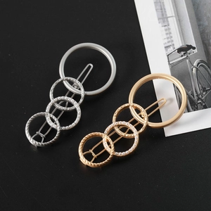 Detail of geometric hair clip with four gold and silver rings and pearl accents