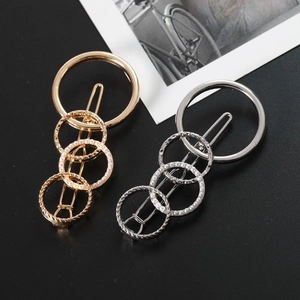 Detailed view of gold and silver geometric circle hair clips with pearls and textures