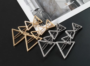 Detail of triangle pearl hair clips in gold and silver finish with spiral textures