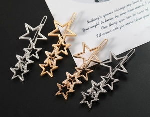 Vue détaillée de quatre pinces à cheveux étoiles avec perles en or, argent et or rose