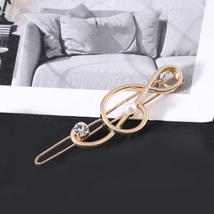 Detailaufnahme der Musiknoten-Haarspange mit Goldlegierung, Perle und Strass-Verzierung