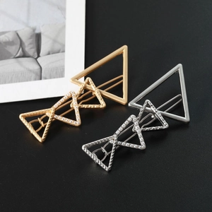 Detailed close-up of gold and silver geometric triangle hair clips with pearl accents