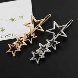 Détail macro de barrettes étoiles dorées et argentées avec perles sur fond sombre