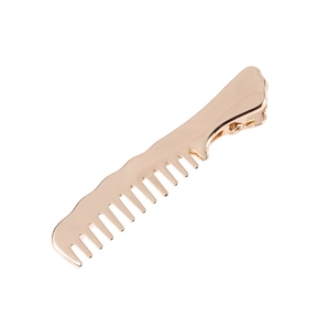 Détail d'une pince à cheveux dorée en forme de peigne avec une finition miroir polie