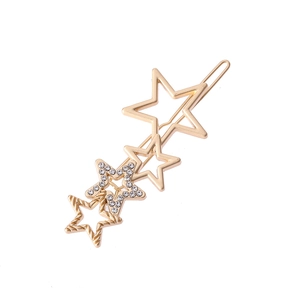 Détail d'une pince à cheveux étoile dorée avec strass scintillants et textures