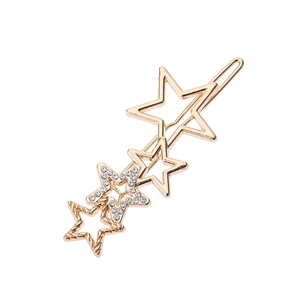 Détail macro de la pince à cheveux étoile dorée avec strass et motifs métalliques