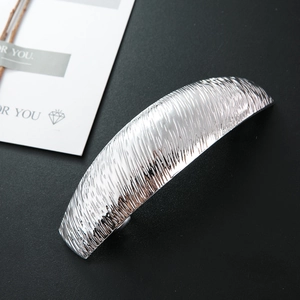 Macro side view of silver alloy hair clip featuring irregular hammered texture design