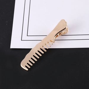 Détail d'une pince à cheveux créative en forme de peigne doré sur fond bicolore moderne