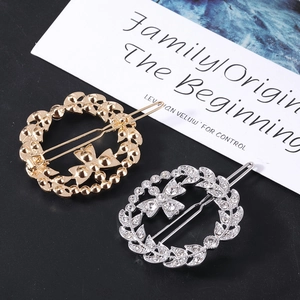 Detailed macro view of hollow leaf wreath hair clips with rhinestone butterfly in gold and silver