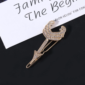Detailed view of Cupid's arrow hair clip featuring gold alloy and sparkling white crystals