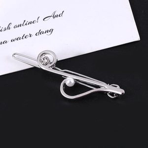 Detail of silver musical note hair clip with white pearl and rhinestone accents