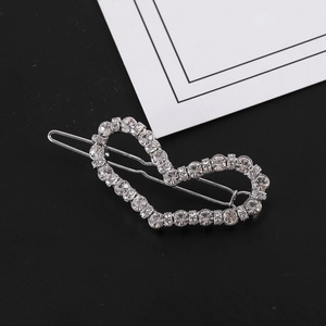 Détail de la pince à cheveux en forme de cœur ornée de strass brillants sur métal argent