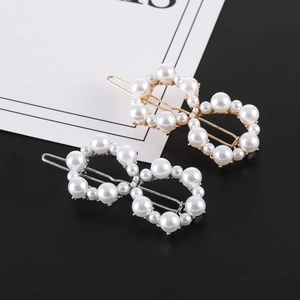 Detail of infinity pearl hair clips in gold and silver metal with rhinestone accents
