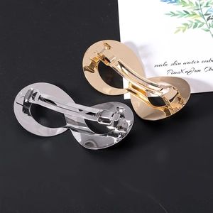 Detail of infinity-shaped metal hair clips in gold and silver finish with spring closure