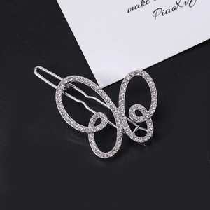 Detailed macro view of silver hollow butterfly hair clip with sparkling white rhinestones