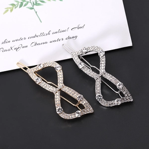 Detailed close-up of gold and silver hollow bow hair clips with rhinestones and pearls