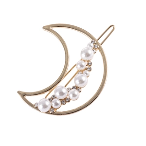 Barrette à cheveux dorée en forme de lune avec perles et strass sur fond blanc