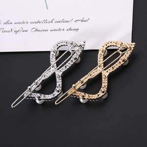 Detailed macro view of gold and silver infinity bow hair clips with pearls and rhinestones