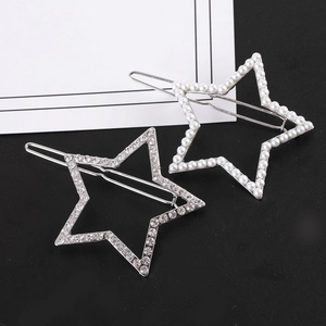 Vue rapprochée de barrettes étoile argentées avec perles et strass sur fond noir et blanc
