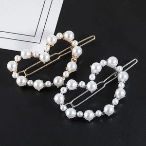 Détail de barrettes à cheveux en forme de cœur avec perles et monture en métal doré et argenté