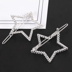 Détail de deux barrettes en forme d'étoile avec des strass blancs et des perles