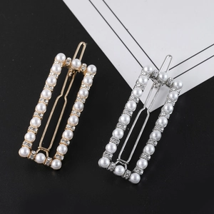 Detailed macro view of pearl and rhinestone rectangular hair clips in gold and silver finish