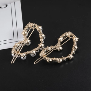Vue détaillée des pinces à cheveux en forme de cœur avec perles et strass dorés