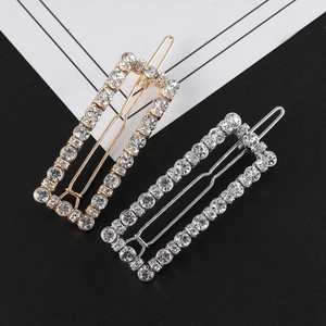Close-up of pearl and rhinestone hair clips in gold and silver rectangular hollow design