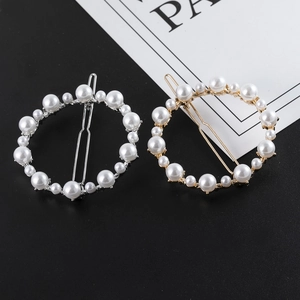 Détail de barrettes circulaires en alliage avec perles et strass sur carte support