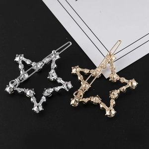 Détail macro de barrettes étoile dorées et argentées avec texture et strass brillants
