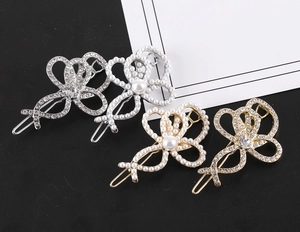 Détail de quatre barrettes à cheveux en strass et perles, finitions dorées et argentées