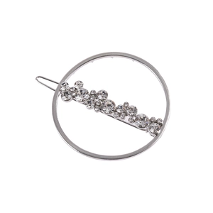 Pince à cheveux ronde argentée avec strass scintillants sur fond blanc pur