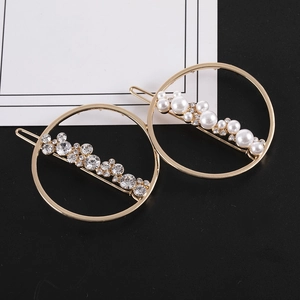 Vue détaillée de deux barrettes dorées ornées de perles blanches et de cristaux brillants
