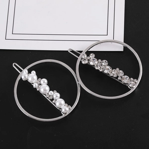 Détail de barrettes rondes avec perles blanches, cristaux et finition métal argenté