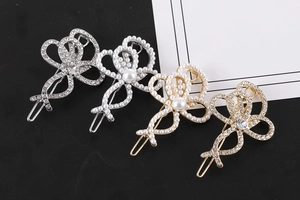Détail de quatre élégantes barrettes à cheveux en strass et perles, tons or et argent