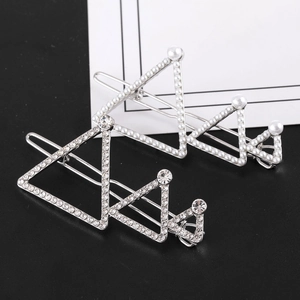 Vue détaillée de deux barrettes argentées avec strass et perles blanches de luxe