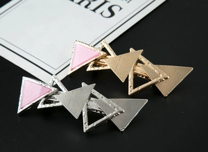 Detailansicht der geometrischen Dreieck-Haarklammer mit rosa glitzerndem Emaille-Inlay