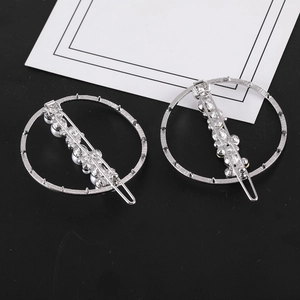 Gros plan de barrettes circulaires en argent avec perles blanches et strass étincelants
