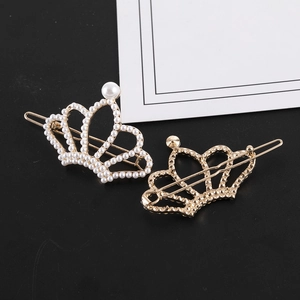Detailed view of hollow crown hair clips with white pearls and gold alloy finish