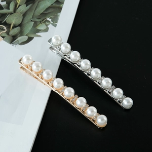 Detalle de pinzas de pelo tipo pico de pato con perlas redondas y brillantes diamantes de imitación