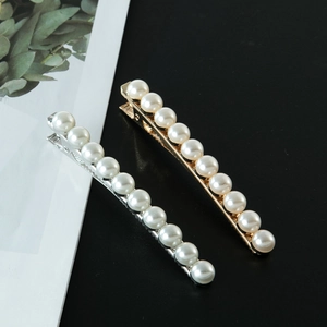 Detalle de elegantes pinzas para el cabello en oro y plata con perlas blancas lisas
