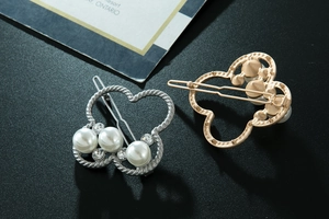Vue détaillée de barrettes papillon avec perles blanches et strass étincelants