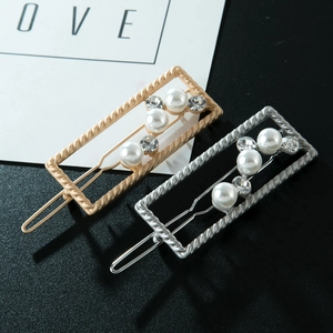 Detailed macro view of gold and silver rectangle hair clips with pearls and rhinestones