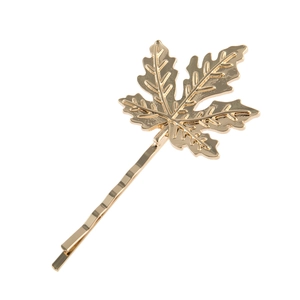 Vue détaillée d'une barrette feuille d'érable dorée avec textures métalliques complexes