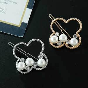 Détail de barrettes papillon or et argent avec perles et strass sur métal torsadé